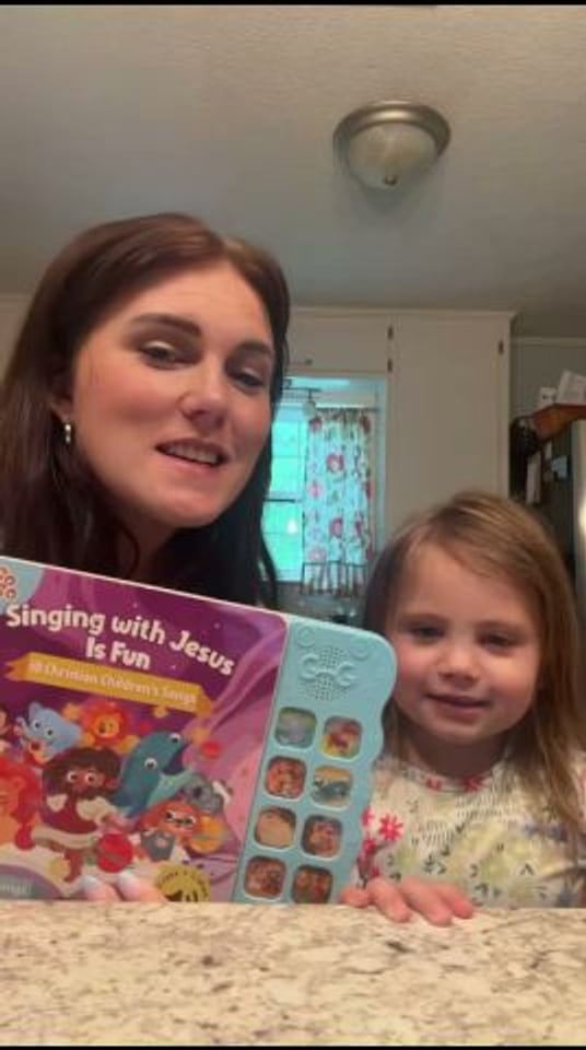 A caregiver and child looking at the Singing with Jesus Is Fun Christian sound book together