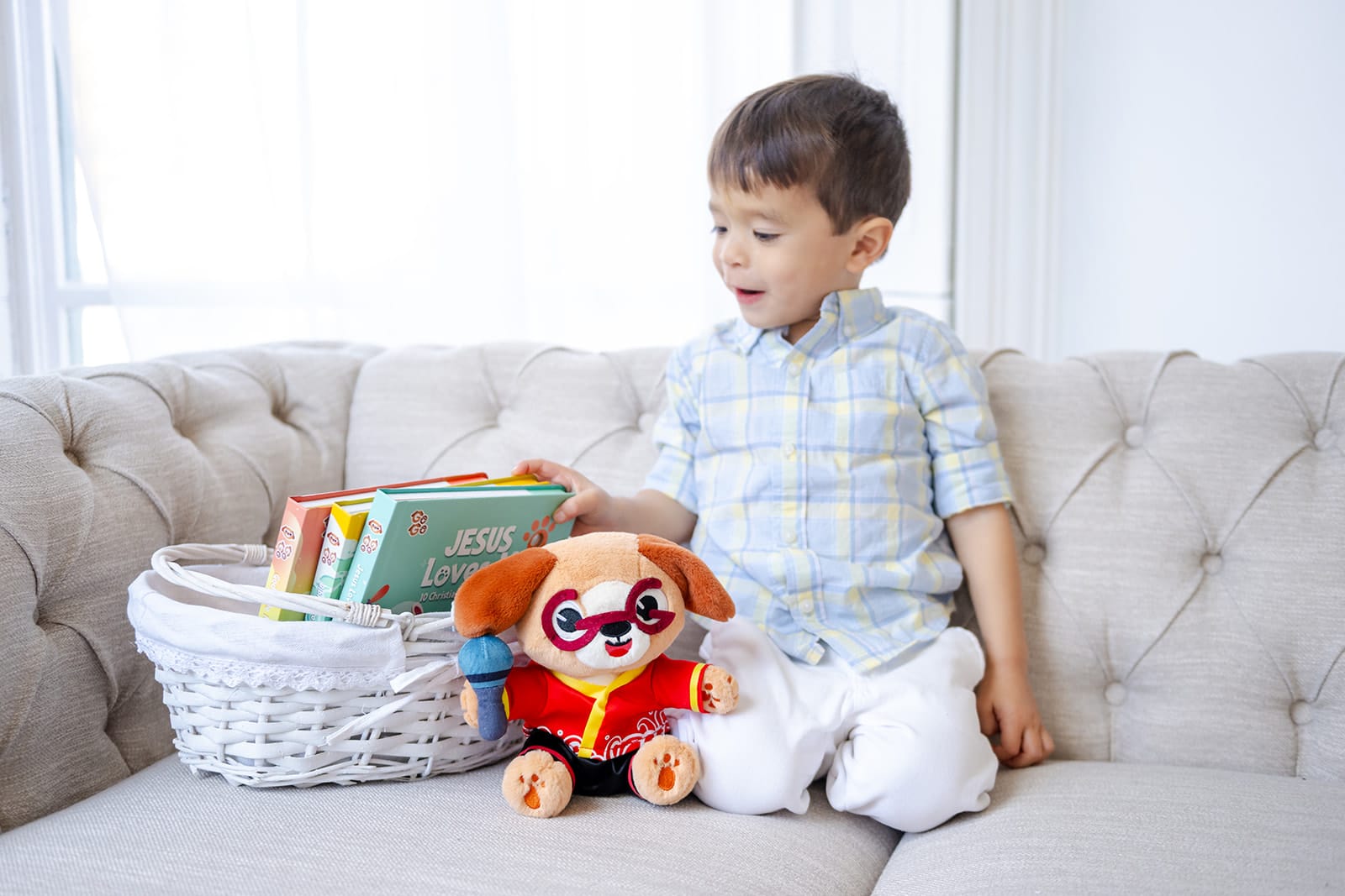 Young child with a basket of Go Go Fun Learning Christian sound books and the Go Go plush mascot