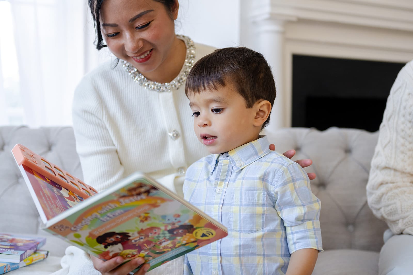 Mom and young boy joyfully reading and singing along to a Go Go Fun Learning sound book